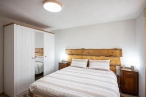 a bedroom with a large white bed with two pillows at Casa Margherita, Lozio Ospitar in Lozio