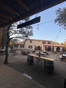 a picnic area with tables and barrels and a building at Ferme auberge U sapè fà in Saliceto