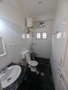 a bathroom with a white toilet and a sink at Urban Dreamspace 2BHK fully furnished in Secunderabad