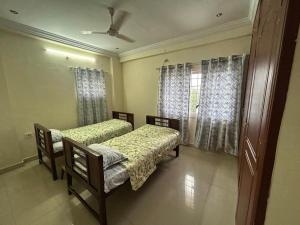 a room with two beds and a window at Urban Dreamspace 2BHK fully furnished in Secunderabad