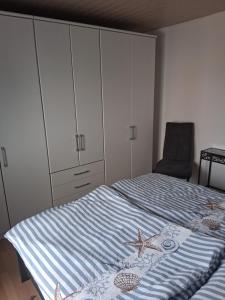 a bedroom with a bed with a dresser and a chair at Ferienhaus Huckenbröl in Eitorf