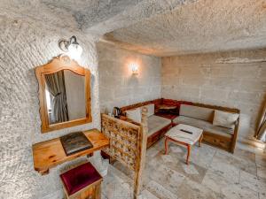 Una sala de estar con un sofá y un espejo. en Erenbey Cave Hotel Adults Only Plus 12, en Göreme