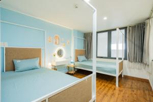 a bedroom with two beds and a mirror at Aluna Residence Homestay in Da Nang