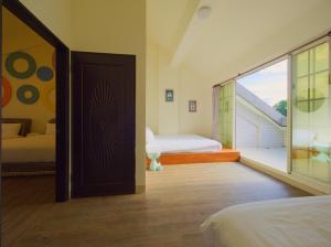a bedroom with two beds and a door with a balcony at 小熊城堡民宿-免費停車 !!新歌KTV-過山車電動麻將-露天烤肉-以上設備僅限包棟使用 # 選Villa才是包棟 # - 16人以下可少人包棟請電聯!! in Hualien City