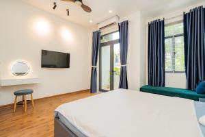 a bedroom with a bed and a flat screen tv at Aluna Residence Homestay in Danang