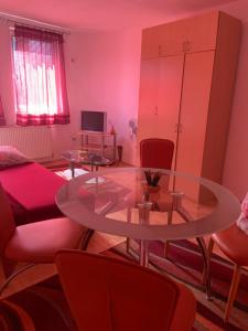 a living room with a glass table and chairs at Urban Hideout City Center Nis in Niš