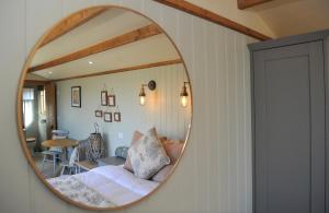 a mirror reflecting a bedroom with a bed and a table at Warblers Meadow in Cambridge