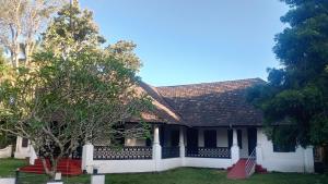 a house with a tiled roof and a yard at Anna's Heritage bungalow in Alleppey
