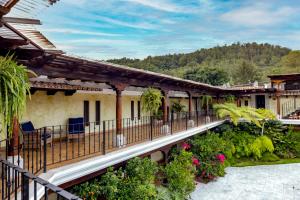 a building with a balcony with flowers and plants at Casa Faustina Boutique Hotel in Antigua Guatemala