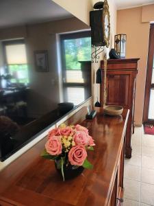 a vase with pink roses on a wooden table at Feldzauber in Ladbergen