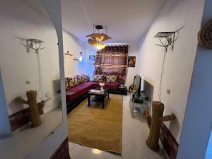 a living room with a red couch and a mirror at Homey vibes in Agadir