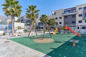 ein leerer Spielplatz mit Rutsche und Schaukeln in der Unterkunft Ático 90m de terraza, jacuzzi privado y cargador de coche eléctrico en Cabria, Almuñecar in Almuñécar