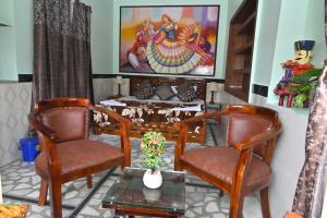 Una sala de estar con dos sillas y un sofá. en Rajputana Heritage Haveli, en Jodhpur