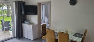 a dining room with a table and chairs and a television at Casa Mia 37 am See in Joachimsthal