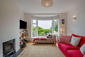 ein Wohnzimmer mit einem roten Sofa und einem Fenster in der Unterkunft The Ferry Cottage in Walton