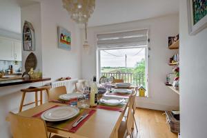 ein Esszimmer mit Tisch und Stühlen und einem Fenster in der Unterkunft The Ferry Cottage in Walton