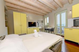a bedroom with a large bed and a kitchen at Magic apartment with view on Garda lake in the center of Desenzano in Desenzano del Garda