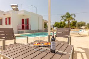 a table with a bottle of wine and glasses on it at Villa Dolcevivere in Specchiolla 