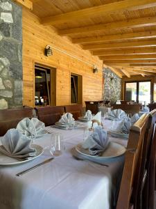ein langer Tisch mit Tellern und Servietten darauf in der Unterkunft Hostel & Camping Rilindja in Valbonë