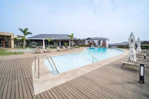 a swimming pool with chairs and umbrellas in a resort at Ballito Hills 164 in Ballito