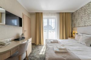 a hotel room with a large bed with towels on it at Villa Cannes Jastarnia in Jastarnia +31 photos