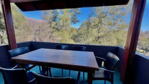 a wooden table and chairs on a balcony with a view at Tata Inti Complejo Serrano in Merlo
