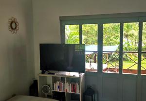 a living room with a flat screen tv and a window at Villa Solazur - ocean view in Bocas Town