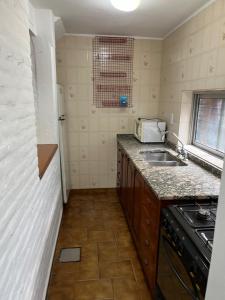 a small kitchen with a sink and a microwave at Apartamento Calamar II in Valeria del Mar +6 photos