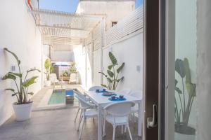 Un comedor blanco con una mesa y sillas blancas. en Casa Charme, en Racale
