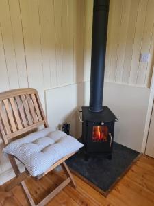 a chair and a wood stove in a room at Shepherd's Hut in heart of the Brecon Beacons in Bwlch