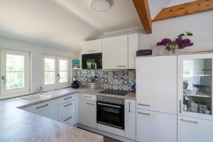 una cucina con mobili bianchi e un forno a piano cottura di SHD19 - FeWo "Gelassenheit" a Neuhaus