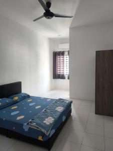 a bedroom with a bed and a ceiling fan at De' Jamboree Homestay in Batu Gajah