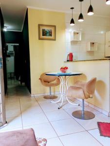 a kitchen with a table and two chairs and a counter at Gama empreendimentos in Campo Grande