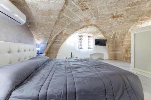 Cama grande en habitación con pared de piedra en Casa Charme, en Racale 16 fotos más