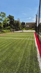 a tennis court with a net and a basketball hoop at Apartamento Vacacional a 5min del Aeropuerto - Con 3 Piscinas - 2 Jacuzzi - Sauna - 20 min Parque del Café - By Molca Travel in La Tebaida