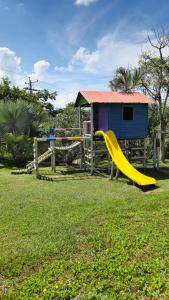 a playground with a slide and a house at Apartamento Vacacional a 5min del Aeropuerto - Con 3 Piscinas - 2 Jacuzzi - Sauna - 20 min Parque del Café - By Molca Travel in La Tebaida