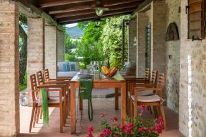 Una mesa y sillas de madera en un patio. en Casale Belvedere 8&1 by Marche Holiday Villas, en Monteciccardo