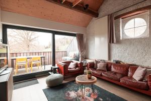 a living room with a couch and a table at Mille Fleur Apartments in Voeren