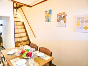 a dining room table with a bowl of fruit on it at Osaka Riverside Inn in Neyagawa