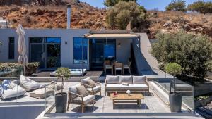 a house with a patio with chairs and a table at Villa Seaview Serenity - Jacuzzi & Panoramic Views in Chania