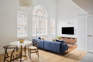 a living room with a blue couch and a table at Rusk House Serviced Apartments in Houston