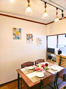 een eetkamer met een houten tafel en stoelen bij Osaka Riverside Inn in Neyagawa