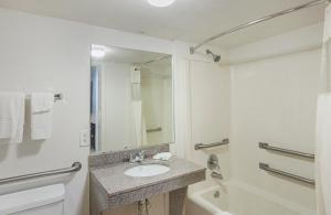 a bathroom with a sink and a tub and a mirror at Studio 6 Fort Worth, TX - Meacham in Fort Worth