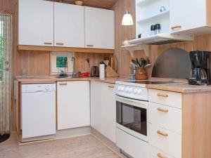 a kitchen with white appliances and wooden cabinets at Lakeview Hideaway - By Traum Ferienwohnungen in Ørby