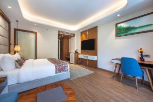 ein Hotelzimmer mit Bett und Schreibtisch in der Unterkunft Snow Valley Heights - An Elegant Air Conditioned Escape by Snow Valley Resorts in Manali + 34 Fotos