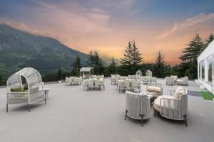 eine Gruppe von Tischen und Stühlen auf einer Terrasse in der Unterkunft Snow Valley Heights - An Elegant Air Conditioned Escape by Snow Valley Resorts in Manali