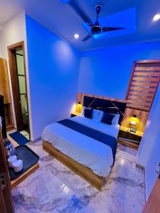 1 dormitorio azul con 1 cama y ventilador de techo en Hotel Paras Inn 2, en Amritsar