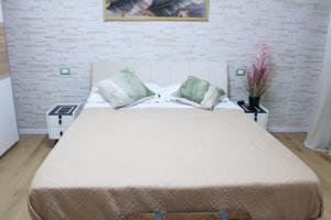 Un dormitorio con una cama grande con dos mesitas de noche. en Argenta Center every comfort, en Argenta