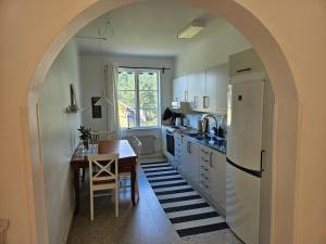 an archway in a kitchen with a table and a refrigerator at Bograngen LGH D in Brograngen