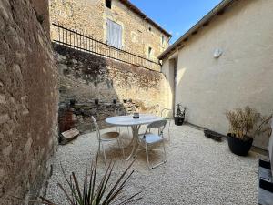 ein weißer Tisch und Stühle in einem Innenhof in der Unterkunft Maison Hythou de ville 6 personnes in Thouars